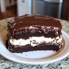 a piece of chocolate cake with white frosting and chocolate icing on a plate