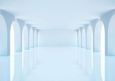 an empty white room with arches and columns