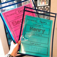 a person holding up three different types of binders in front of a bulletin board