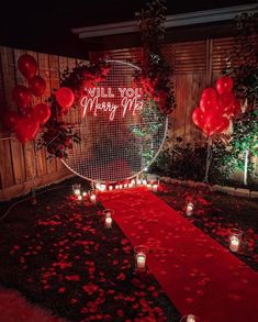 a red carpet with candles and balloons on it