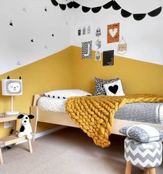 a child's bedroom with yellow walls and black and white decor