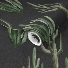 a black background with green and white plants on the wall next to a roll of toilet paper