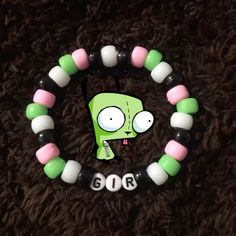 a green and white beaded bracelet with an odd face