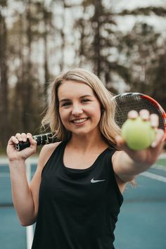 a woman holding a tennis racket and ball