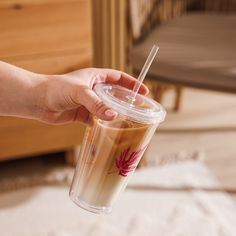 a person holding a cup with a straw in it