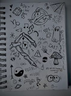 a notebook covered in doodles and drawings on top of a white paper sheet with black ink