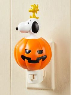 a pumpkin shaped light switch cover with a dog on top