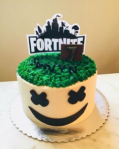 a cake decorated with green grass and a fortnife topper