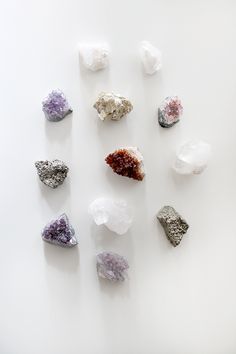 several different types of rocks on a white surface