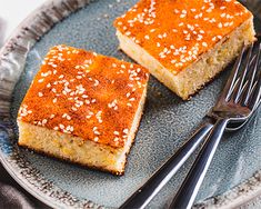 two pieces of cake on a plate with silverware