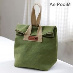 a green bag sitting on top of a white bed