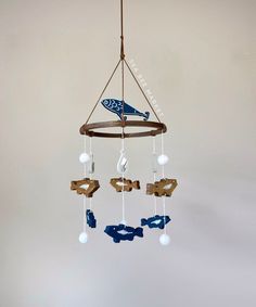 a blue and white airplane is hanging from a wooden chandelier with glass beads