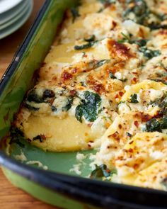 a casserole dish with spinach, cheese and other toppings on it