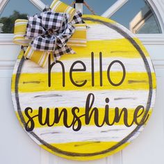 a yellow and white sign that says hello sunshine on the front door with a bow