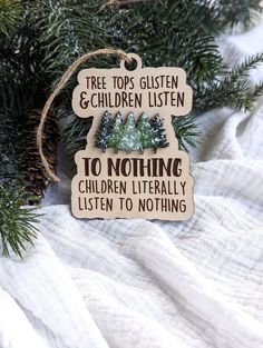 a christmas ornament hanging from a tree with the words, trees glisten and children listen to nothing children literally listen to nothing