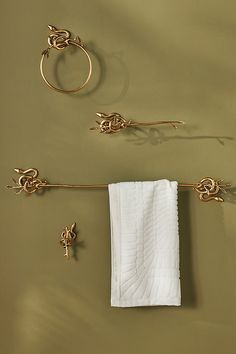 a towel hanging on the wall next to two gold rings and an object that looks like a ring