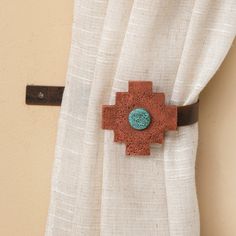 a close up of a curtain with a brown and blue button on it's side