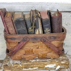 a basket filled with old books on top of a wooden table