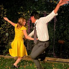 a man and woman are dancing in the grass