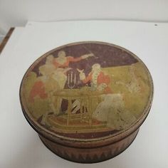 an old tin box with some pictures on it