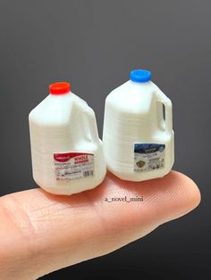 two plastic milk jugs sitting on top of a hand