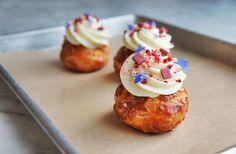 three small pastries with white frosting and sprinkles