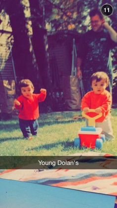 two young children playing with toys in the yard