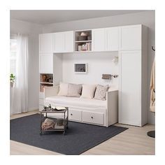 a living room filled with furniture and lots of white cupboards next to a window