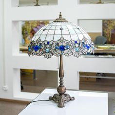 a table lamp sitting on top of a white counter next to a mirror and desk