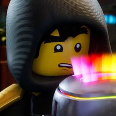 the lego movie character is holding a glowing object in his hand and looking at it