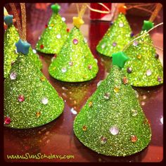 green glitter christmas trees are sitting on a table