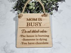 a wooden sign that says, mom is busy do not disturb unless the house is burning someone is dying you have chocolate