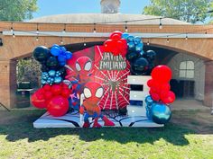 the entrance to an event with balloons and spiderman decorations