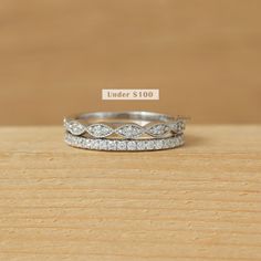 a stack of three rings sitting on top of a wooden table next to a price label