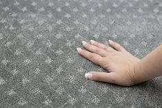 a person's hand on the ground with their left hand resting on the carpet