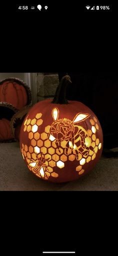 a carved pumpkin with bees and honeycombs on it