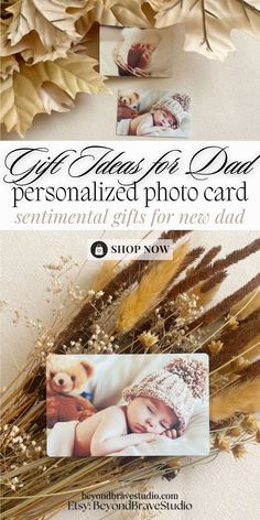 an advertisement for a baby's photo card with flowers and feathers on the table