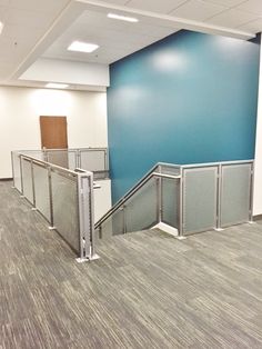 an empty room with blue walls and metal railings