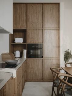 a kitchen with wooden cabinets and an oven in the center, next to a dining room table