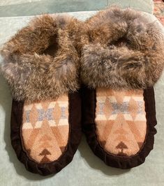 These are a new pair of handmade moccasins.  They are made by myself, an indigenous Canadian Ojibwe woman.  They have chocolate brown deer suede soles, with Pendleton brand wool vamps. They are trimmed with rabbit fur. According to the shoe size chart, they would fit Women's size 10, or a men's 8.5  They measure approximately 10.25  inches from heel to toe and 4.25 inches across the ball of foot. Thank You. Handmade Moccasins, Antler Earrings, Brown Deer, Moccasins Women, Moccasins Mens, Suede Moccasins, Fur Shoes, Hunting Boots, Moccasin Boots