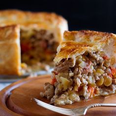 a piece of meat and vegetable pie on a plate with a fork next to it