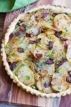 a baked dish with potatoes and bacon on a cutting board