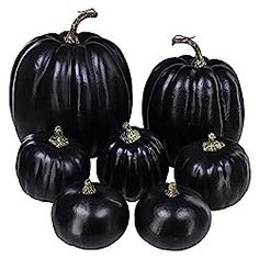 six black pumpkins are arranged on a white background