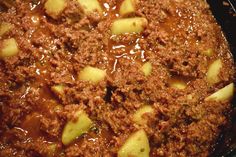 a pot filled with meat and potatoes covered in gravy on top of a stove