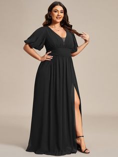 a woman in a long black dress posing for the camera with her hands on her hips