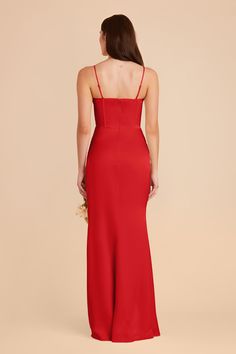 the back of a woman wearing a red dress with spaghetti straps and high slits