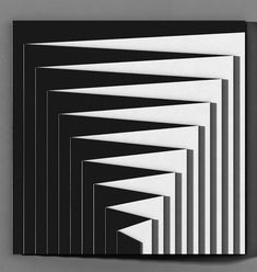 an abstract black and white artwork piece on a gray wall with vertical lines in the center