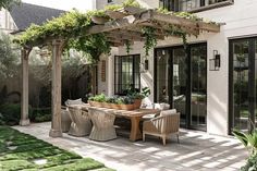 an outdoor dining area with wicker chairs and table surrounded by greenery on the patio