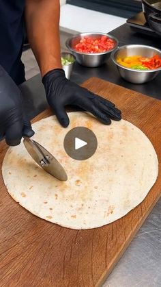 a person cutting up food on top of a wooden board