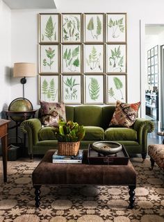 a living room with green couches and pictures on the wall above them, along with a coffee table